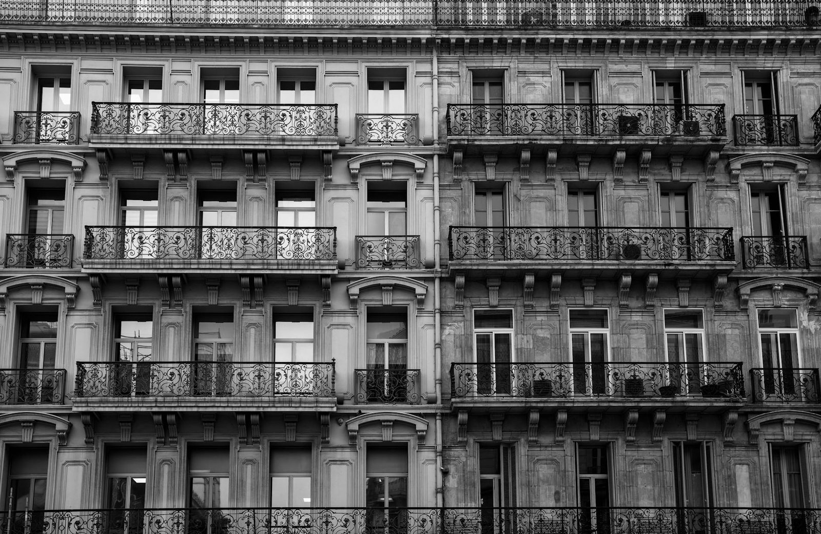 Elegant black and white photo of a historic building facade in Toulon, France with ornate balconies.