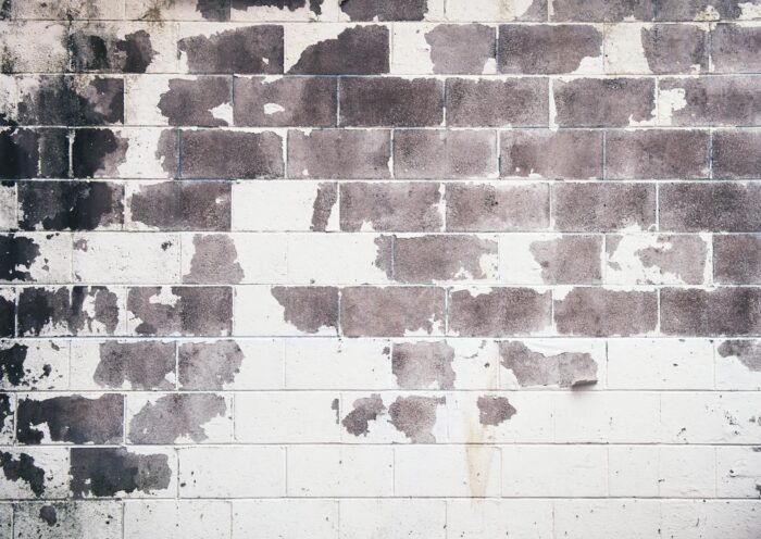 Detailed grunge texture of an old brick wall with peeling paint and rustic feel.