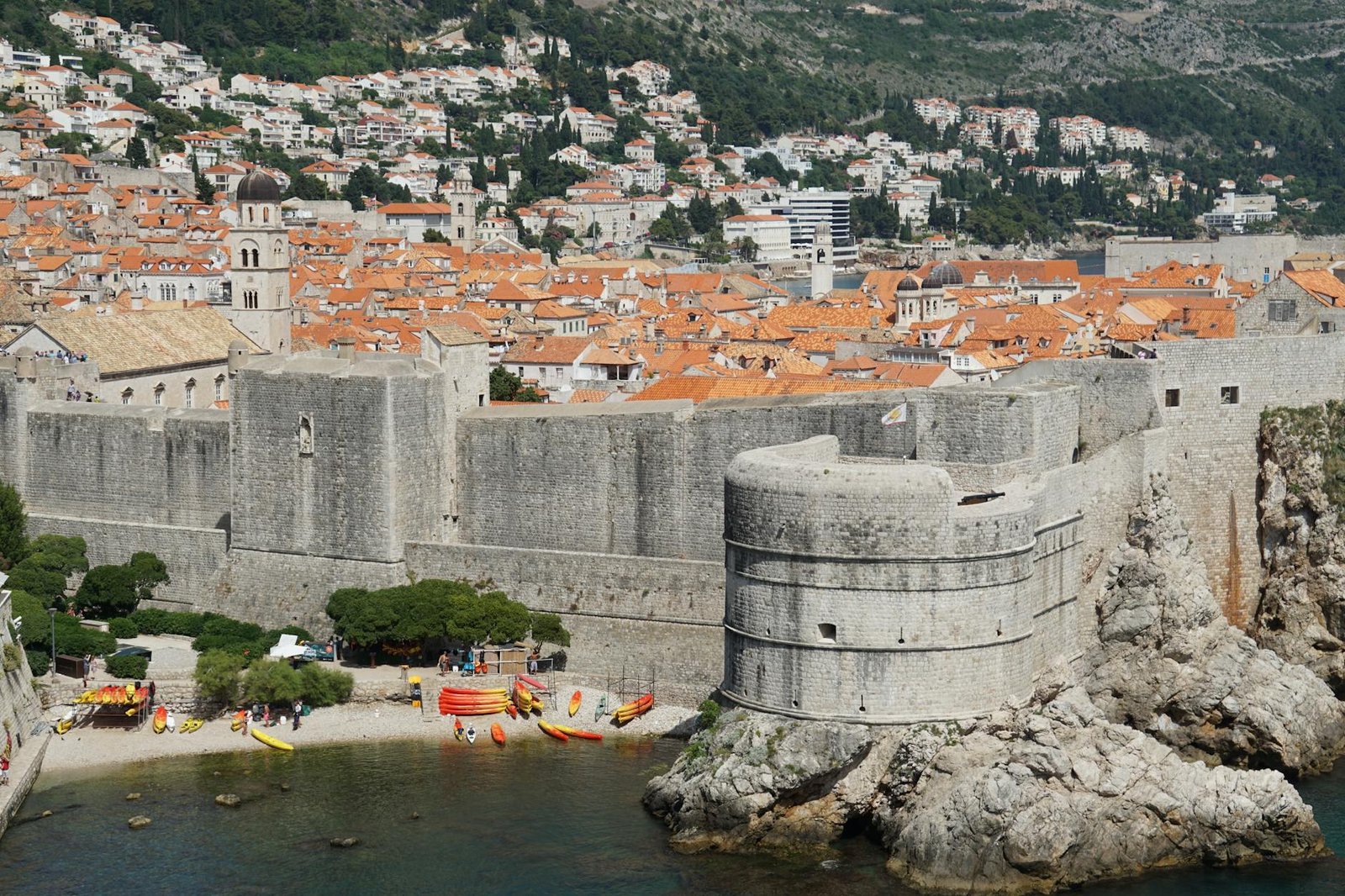 Scenic view of Dubrovnik's historic stone walls and coastline, showcasing medieval architecture.
