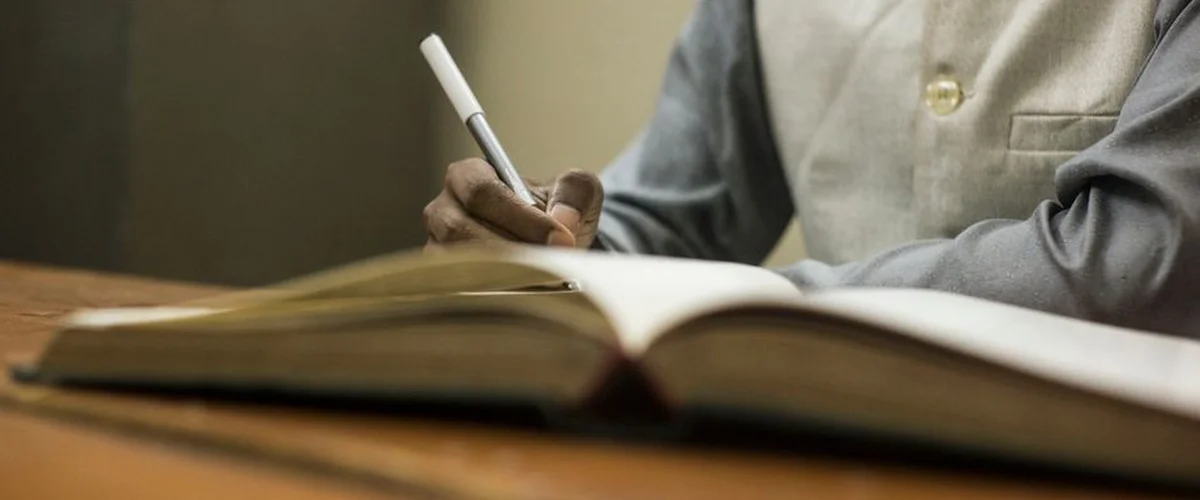 Student writing reading log in library — reading level conversion benchmark