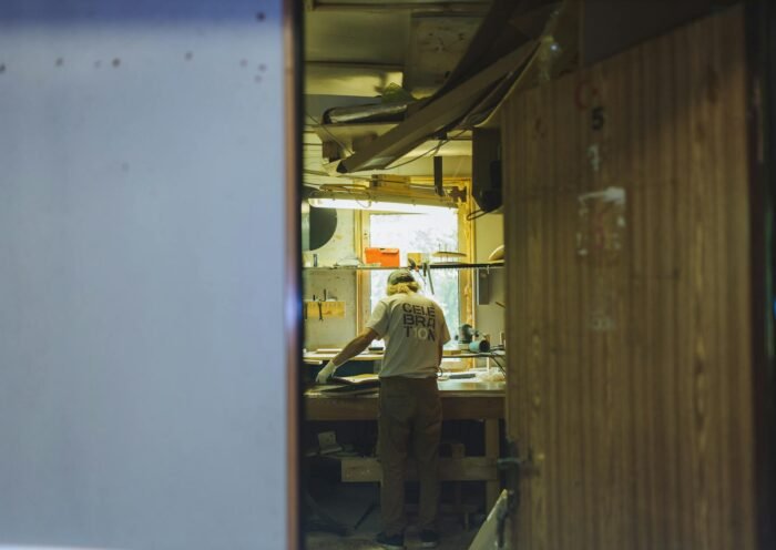 A craftsman works diligently at a workbench in a cozy, rustic workshop.