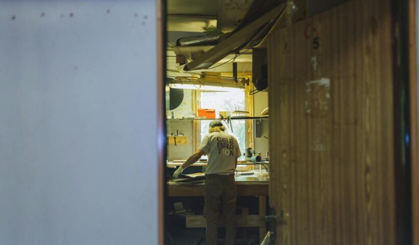A craftsman works diligently at a workbench in a cozy, rustic workshop.