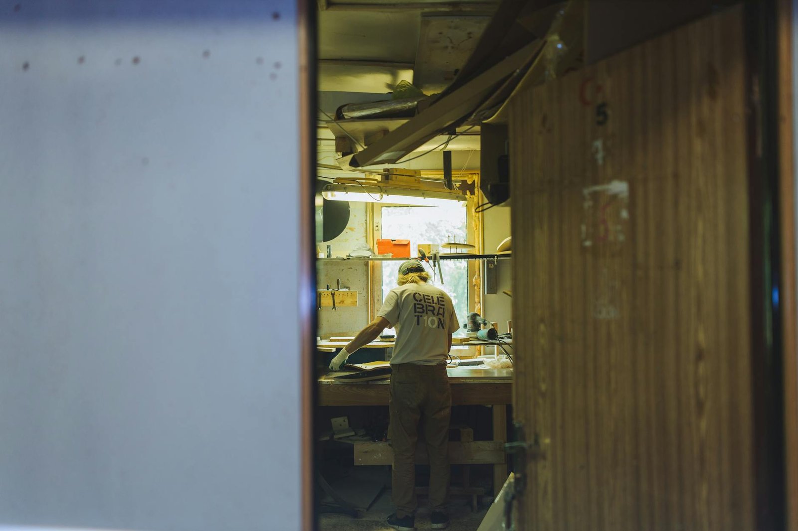 A craftsman works diligently at a workbench in a cozy, rustic workshop.